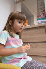 Young girl enjoying mandarin in cozy room