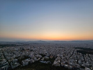 Fototapeta premium Sunset in Athens with a view of the mountains and the setting sun