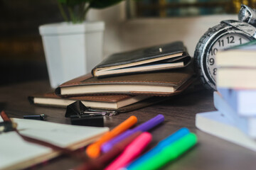 Several stacks of books and pencils are on the wooden table, education concept