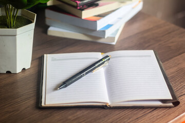 Several stacks of books and pencils are on the wooden table, education concept