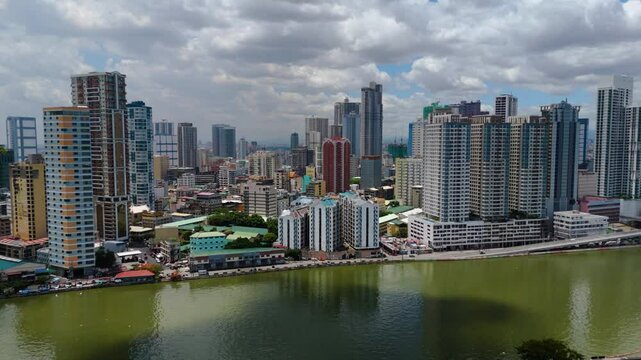 Aerial view of Binondo&rsquo;s modern skyline and bridges over the Pasig River with a dense urban sprawl and mountains in the distance &ndash; Manila, Philippines