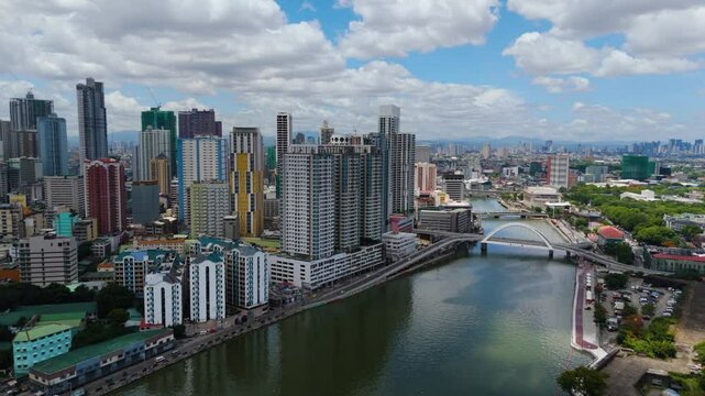 Aerial view of Binondo&rsquo;s modern skyline and bridges over the Pasig River with a dense urban sprawl and mountains in the distance &ndash; Manila, Philippines