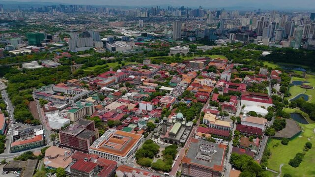 Drone view of the entire Intramuros historic walled district with its churches, old buildings, and manicured greenery surrounded by modern Manila &ndash; Manila, Philippines
