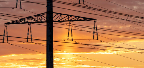 High-voltage power lines in the background of sunset or dawn