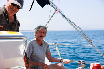 Senior friends laughing and enjoying sailing trip in Costa Brava, Spain
