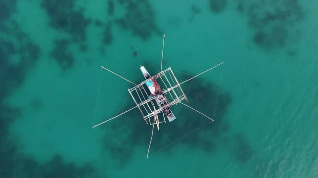 Birds eye top aerial view of Colorful Bangka Boat that looks like an octagon Floating off the Coast of Pamilacan Island, Panglao, Bohol, Philippines