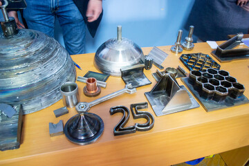 Objects printed on 3D printer from filament of molten metal on table. Object printed by 3D printer from metal. Additive manufacturing solution. Object created on 3D printer from melting metal thread