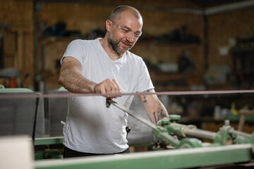 Carpenter using belt sander in workshop: woodworking expertise and precision
