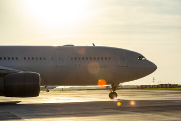 Close-up of wide body airplane at airport in morning sunlight