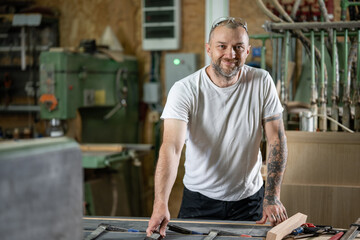Carpenter smiling and working in his workshop