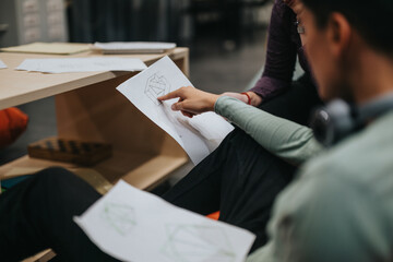 A group of high school students participate in a collaborative classroom activity, examining geometric designs and discussing project ideas. The setting inspires learning, creativity, and teamwork