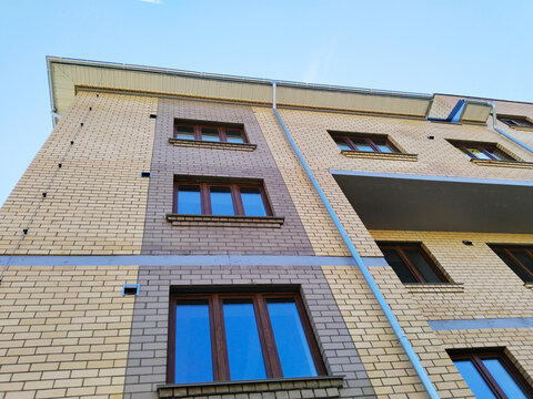 Facade of new multi-story building. Sale and rental apartments. Housing affordability and development. Cityscape. City living. Commercial Real estate investing. Mortgage concept. developer. Window.