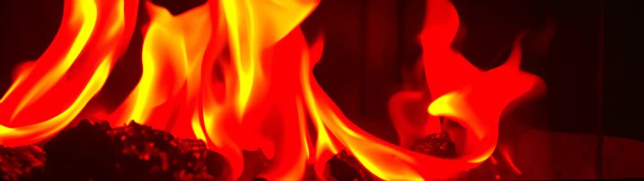 Flames are burning in a black room with a black background