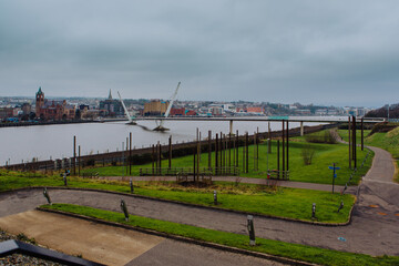 Ireland and NortThe elegant Peace Bridge gracefully curves across the River Foyle, symbolizing...