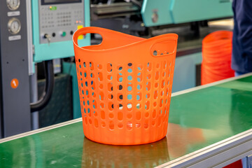 Orange plastic basket on conveyor belt in factory.