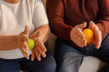 Senior Couple Using Spiky Massage Balls for Hand Exercise Rehabilitation and Pain Relief at Home