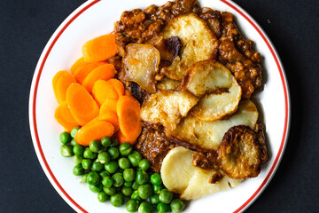 Traditional British Favourite Beef Hotpot With Carrots and Peas