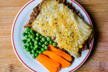 Vegetarian or Veggie Cottage Pie With Carrots And Peas Topped With Mash Potato