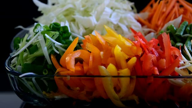 Vibrant, healthy vegetable medley of shredded cabbage, julienned carrots, red and yellow bell peppers, scallions, and beans, perfect for meal prep or vegan recipes.