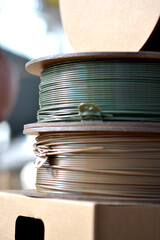 Plastic wire for 3d printer. Spools of plastic threads for printing on 3D printer. Spool of filament. Plastic for 3D printer. Components for 3D printing. New modern additive printing FDM technology