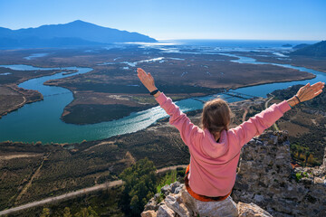 Woman looking from acropolis on top of mount of ancient Greek city Kaunos to Dalyan river, Sulungur...