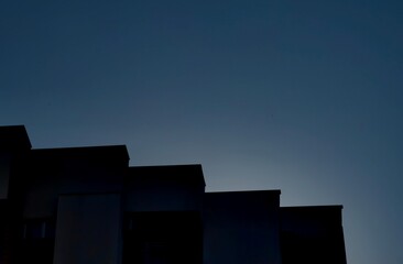 Cascading Rooftop Silhouettes Against Dramatic Cloudy Sky