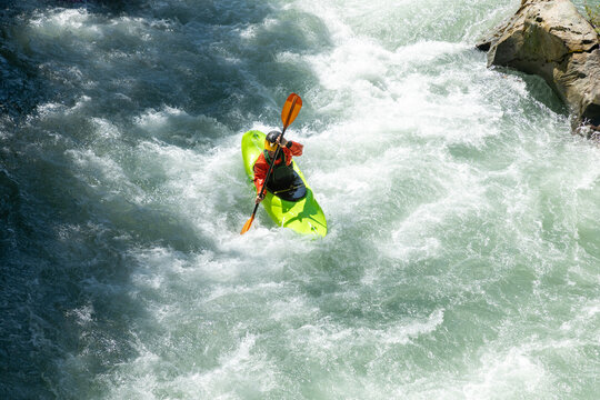 Kayaker navigating through rapid river waters