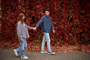 Young Cute Female Hugs Boyfriend. In Autumn Outdoor. Lovers Walking in Park. Attractive Funny Couple. Lovestory in Forest. Man and Woman. Cute Lovers in the Park. Family Concept. Happy Couple.