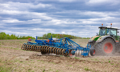 Farmer in tractor preparing land for sowing. Farmer in tractor preparing land with seedbed...