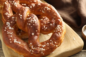 Tasty pretzels with salt on table, closeup