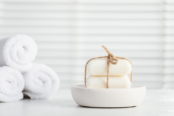 Soap bars and towels on white table indoors, closeup