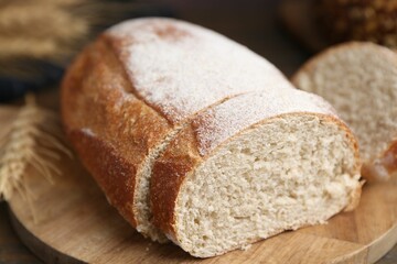 Fresh cut bread on wooden board, closeup