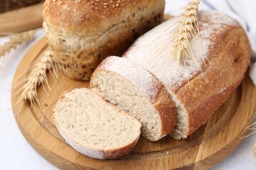 Freshly baked loaves of bread and spikes on light table, closeup