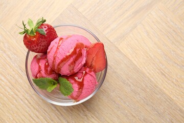 Refreshing sorbet with syrup, strawberries and mint in bowl on wooden table, top view. Space for text