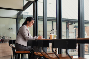 Young woman sitting and working in a cafe