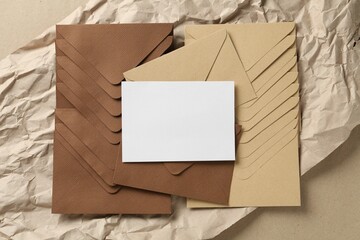 Blank invitation card, envelopes and parchment paper on carton, top view. Space for design