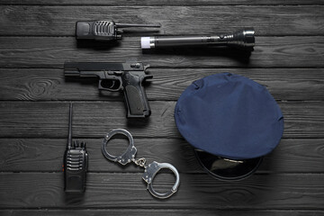 Different police equipment on black wooden table, flat lay