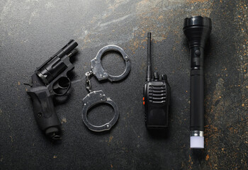 Different police equipment on dark table, flat lay