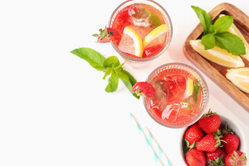 Refreshing drink with strawberries, mint, lemon and ice on white table, flat lay. Space for text
