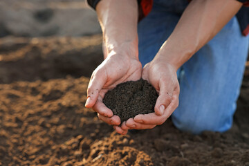 Man holding pile of soil in field, closeup