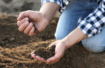 Man with pile of soil in field, closeup