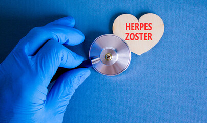 Herpes zoster symbol. Concept words Herpes zoster on beautiful wooden heart. Doctor's hand in blue...