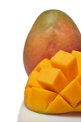 Ripe mango depicted with vibrant, cubed flesh alongside its whole fruit on a white background.