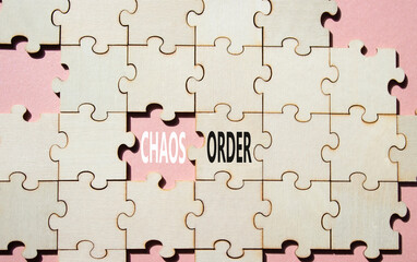 Chaos or Order symbol. Concept word Chaos or Order on wooden puzzle. Beautiful pink background....