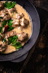 Meatballs in sour cream sauce in a frying pan