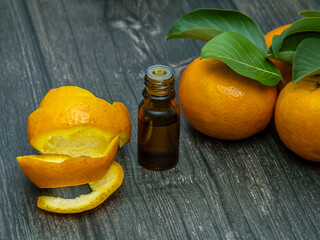 Essential oil of citrus fruits of tangerine in a smaller bottle.