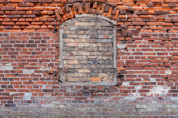Historic Brick Wall with Bricked-Up Window in Urban Setting