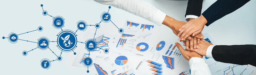 A dynamic business meeting scene showcasing hands coming together over various financial charts,...