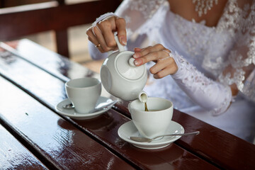 Pouring tea into cup at outdoor table
