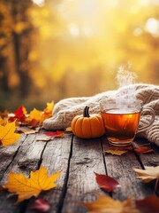 Cozy autumn arrangement with pumpkin, tea, and colorful leaves on wooden table